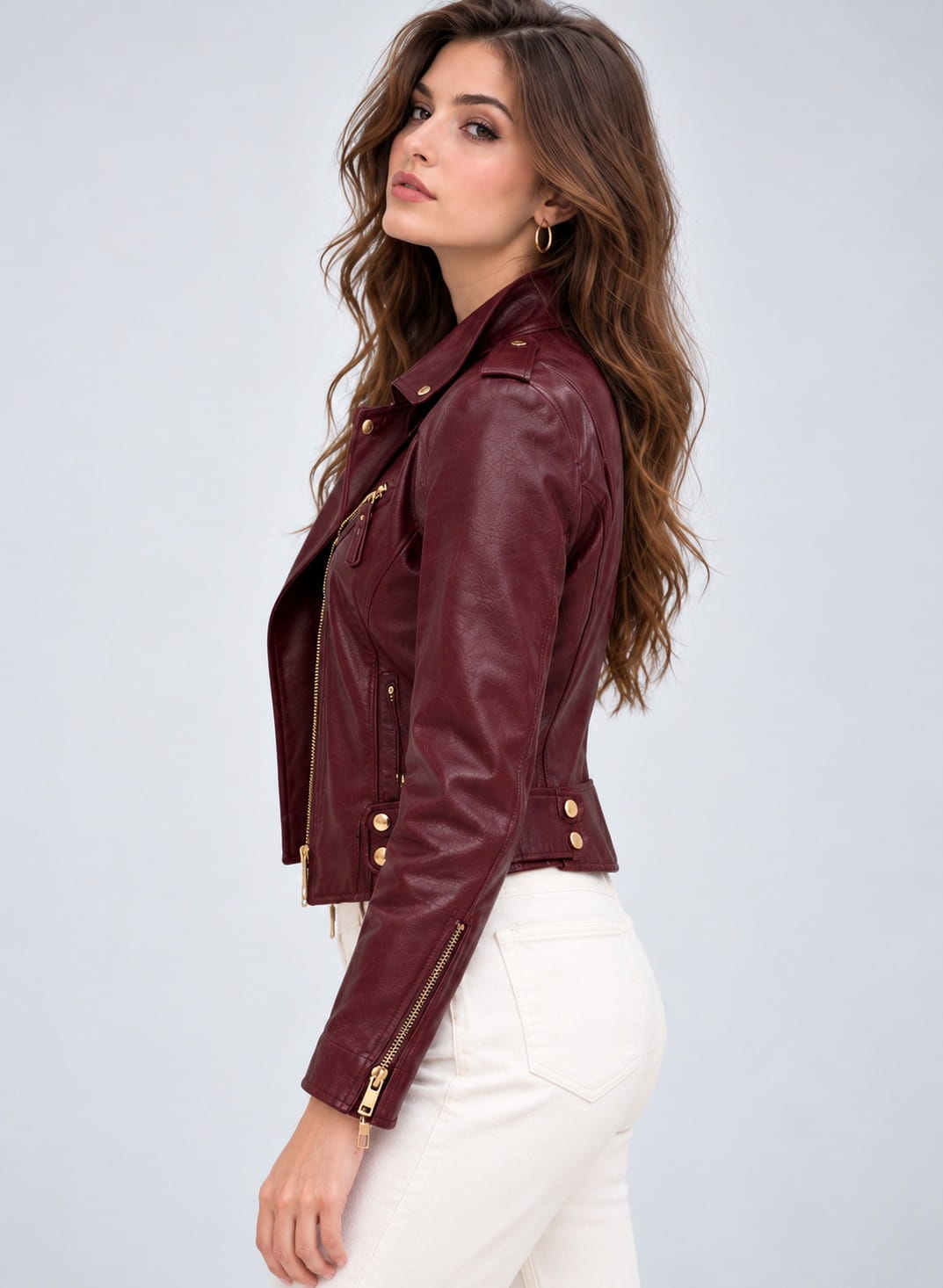 Side view of women's burgundy leather biker jacket with shoulder epaulette, zippered cuff and waist snap tabs