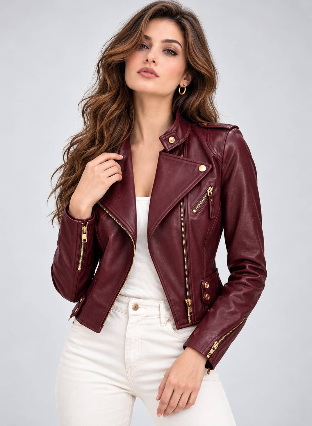 Women's burgundy asymmetric-zip biker jacket with gold-tone hardware styled with a white top and light jeans